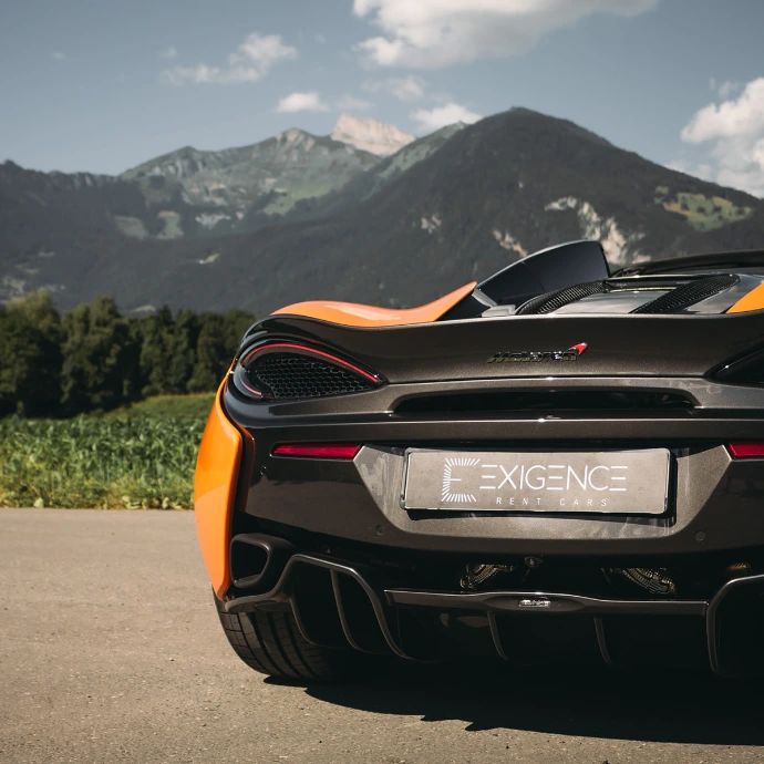 Vue arrière de la McLaren 570S Spider, échappements centraux et finitions carbone. Location McLaren en Suisse.