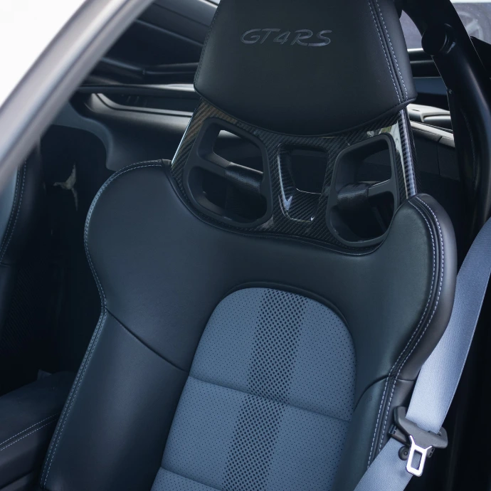 Sièges baquets Porsche GT4 RS, maintien optimal pour conduite dynamique. Supercar à louer en Suisse.