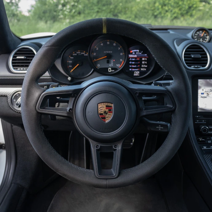 Intérieur Porsche GT4 RS, cockpit minimaliste et ambiance circuit. Location voiture sportive Suisse.