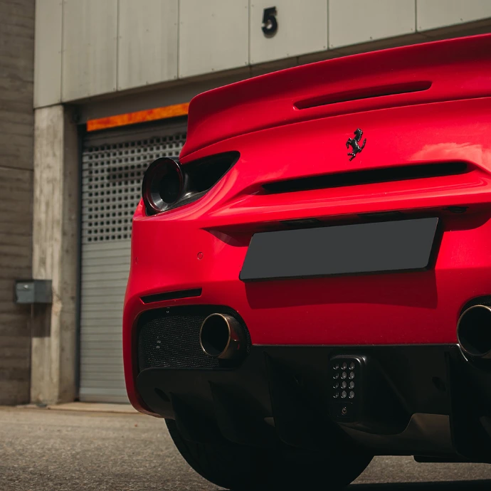 Vue arrière Ferrari 488 GTB, échappements et diffuseur sportif. Location Suisse.