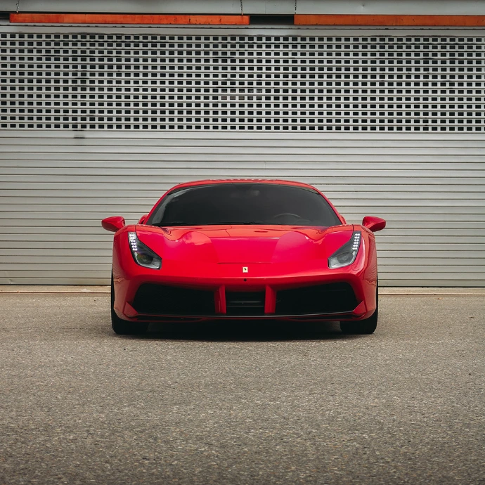 Vue avant Ferrari 488 GTB, signature lumineuse et aérodynamique travaillée. Suisse.